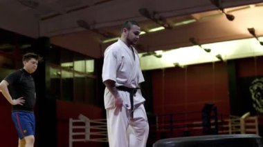 Geleneksel kimono ustası hafif spor salonunda lastik atlayışı yapıyor.