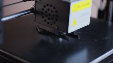 3D yazdırma makinesi sıcak plastiği uygularken siyah ayrıntı veriyor