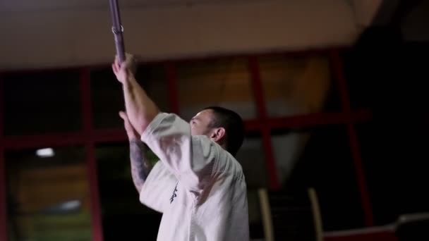 Karate meester in kimono doet oefeningen met bar-bell in de sportschool — Stockvideo