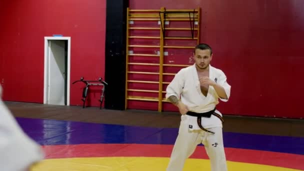 Sportember kimonóban elmagyarázza karate mozog tornaterem edzés — Stock videók