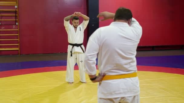 Master en kimono descansa después de entrenar paseando a los estudiantes — Vídeos de Stock