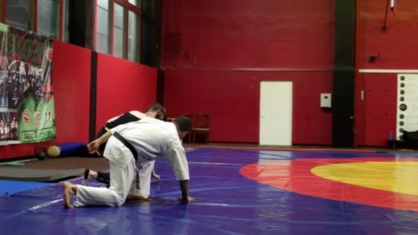 Karate meester shows draaien om vrouw student op tatami in de sportschool — Stockvideo