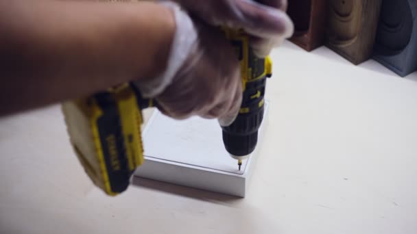 Az alkalmazott csavarokat csavar kis fehér dobozban fúróval az asztalnál — Stock videók