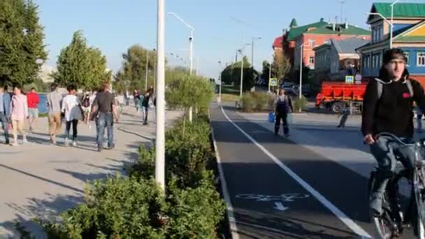 Les personnes positives font du vélo et marchent le long du remblai de la ville — Video