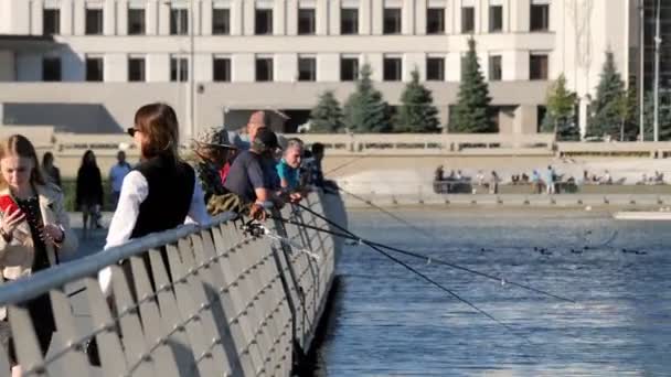 Vissers met hengels staan in de buurt reling op de dijk van de stad — Stockvideo