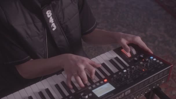 Young man plays digital synthesizer in dark room at concert — Stock Video