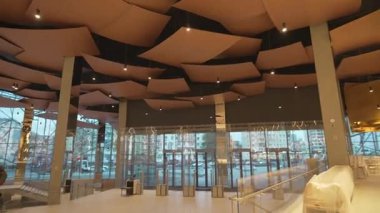 Dekoratif tavan panelleriyle dolu panoramik giriş salonu etkileyici bir şekilde parlıyor. Panoramik cam ve tavan tasarımı ihtişam ahengi yaratır