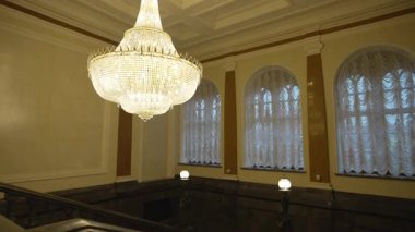 Kristal avize, karmaşık merdiven geçişleriyle geniş bir salonu taçlandırıyor. Kristal dekor mimari tarzın zenginliğini vurguluyor