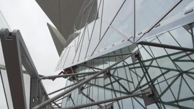 Keskin projeksiyon blokları alanı genişletir ve şehirsel bileşime güç verir. Metalik ritim desen dengesi ekliyor. Dekoratif derinlik