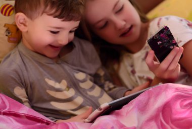 Bulanık görüntü. Yatakta gadget'lar ile oynayan çocuk. Bulanık görüntü. Bulanık resim