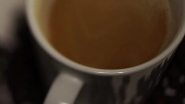 Bulanık film. Kahve makinesi kahve beyaz bir bardağa dökülür