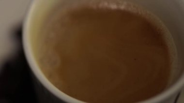 Bulanık film. Kahve makinesi kahve beyaz bir bardağa dökülür