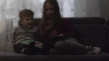 Çocuk bir kitap değerlendiriyorlar. Bulanık film 