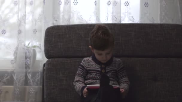 Entzückender Junge Der Auf Dem Sofa Wohnzimmer Sitzt Und Mit — Stockvideo