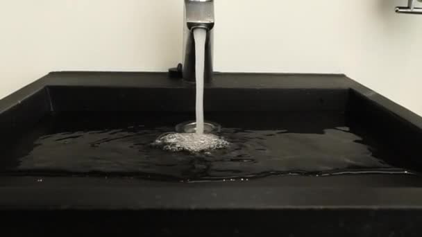 クロム鋼のバスルームのタップから水が流れます ゆっくりズームインします 強い水の流れ — ストック動画