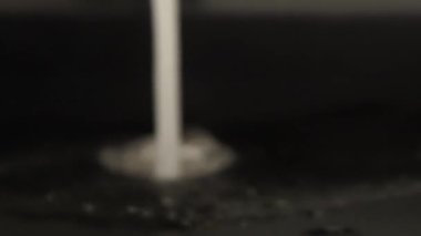 Krom çelikten banyo musluğundan su akar. Yaklaş, yavaşça yakınlaş. Güçlü su akışı
