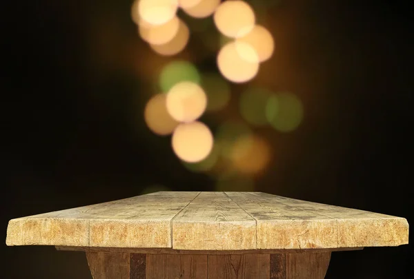 Wooden table top with abstract blurred bokeh background.