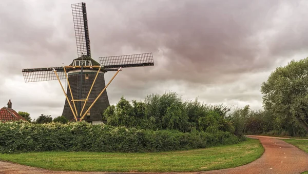 Stary Młyn wiatrowy na dramatycznym zachmurzone niebo w Holandii. — Zdjęcie stockowe