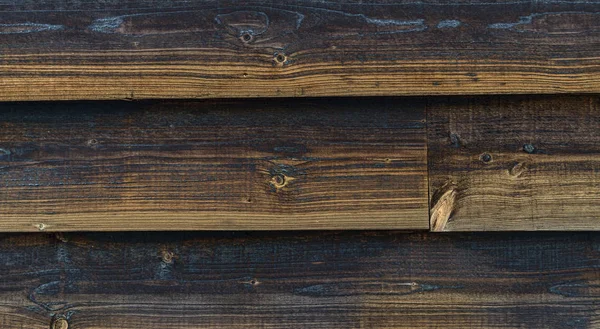 Textur einer alten dunklen, unbemalten Wand aus Holzbrettern — Stockfoto