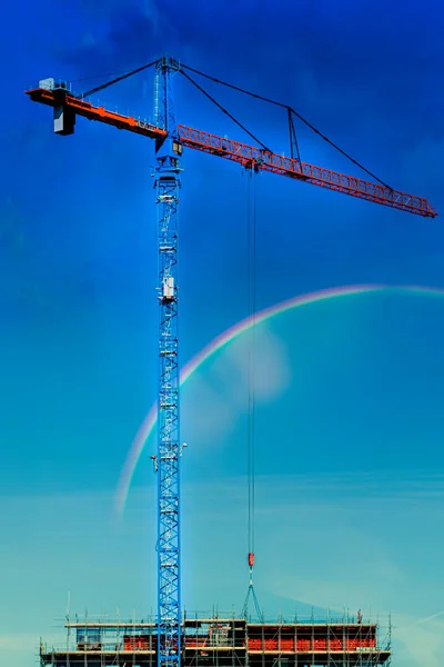 Tower crane and building construction on a background of blue sky