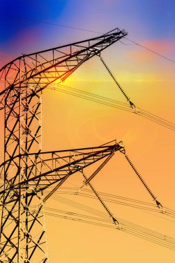 Yüksek voltajlı elektrik hatlarının siluetleri. Günbatımında Elektrik Sütunları