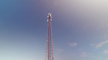 Hücresel anten kulesi ve elektronik radyo alıcı-verici cihazı mavi gökyüzünün altındaki bir hücresel ağın parçası. Telsiz vericisi pilonu. 4K 
