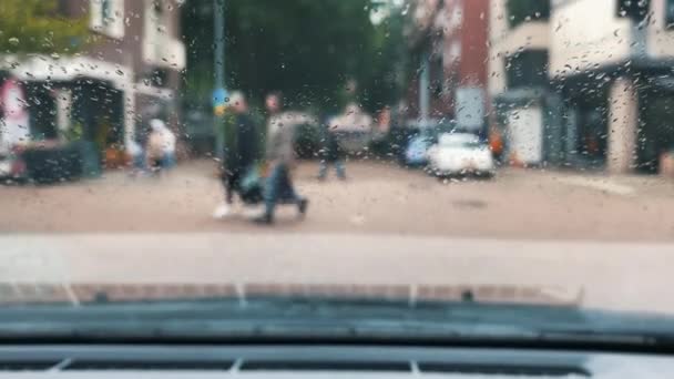 从车内往外看 雨落在汽车挡风玻璃上 道路上模糊的背景和纹理交通 — 图库视频影像