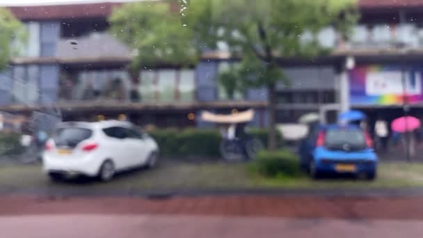 選択的な焦点 フロントガラスに雨の滴 悪天候下で市内の交通車 車内から外への眺め — ストック動画