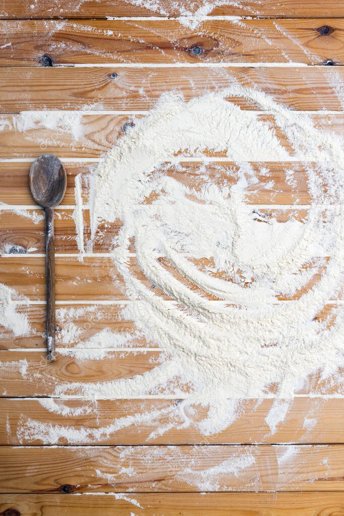 Flour scattered on the wooden table. Flour on the table surface. Baking  background 