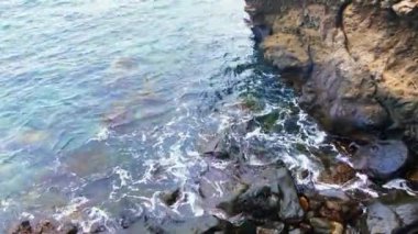 Mavi okyanusun güzel manzarası. Dalgaların kayalara çarpıp köpürdüğü Derin Mavi Deniz 
