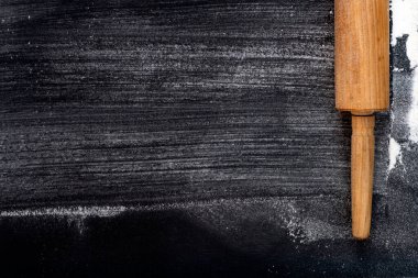 Koyu bir arka planda merdane ve buğday unu. Metin için boş alan. Üst Görünüm