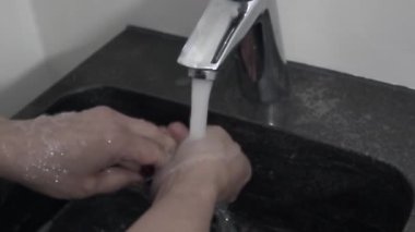 Kadınlar musluğun altında sabun ve ellerini yıkarlar.. 