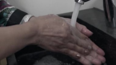 Kadınlar musluğun altında sabun ve ellerini yıkarlar.. 
