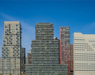 Rotterdam, Hollanda. 06.09.2025, Rotterdam rıhtım manzaralı modern ofis ve yerleşim binaları suya yansıdı, rıhtımdan ön planda büyük bir demirleme borusuyla yakalandı.