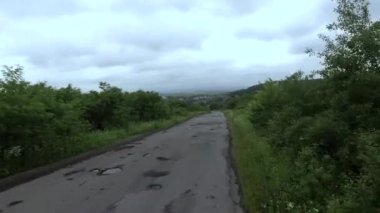 Kötü asfalt bir yolda, çukurlu bir arabadan ateş etmek.