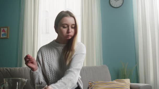 Giovane ragazza con i capelli biondi mette un bicchiere e si prepara a mangiare sushi — Video Stock