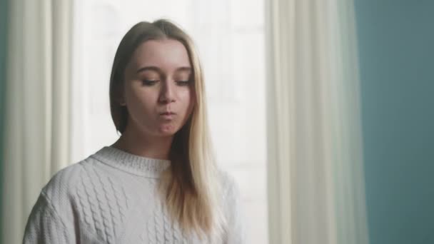 Blond flicka i vit jacka håller ätpinnar för sushi och rätar ut håret — Stockvideo