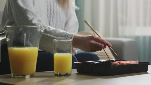 Las niñas mano con palillos trata de tomar sushi, pero lo pierde — Vídeo de stock