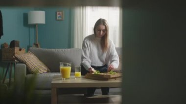 Beyaz ceketli kız pizza yiyor.