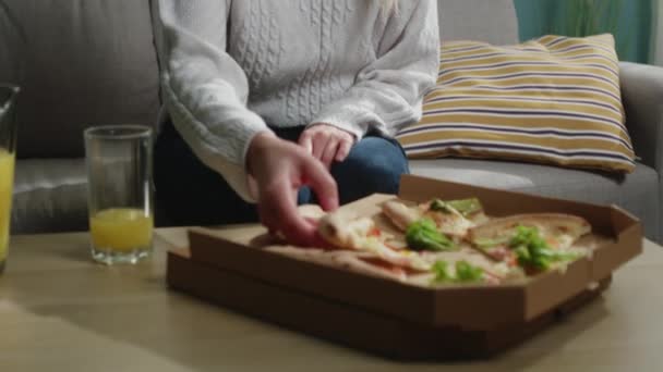 Chica en un suéter blanco se come una rebanada de pizza italiana — Vídeo de stock