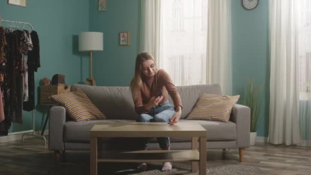 Menina em camisola marrom e jeans tira um hamster de telefone celular — Vídeo de Stock