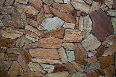 Çok renkli ve çok boyutlu, turuncu ve kahverengi taş duvar grunge doku arka plan.