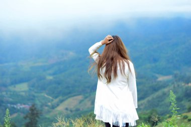 Doğaya bakan genç bir kadın tatil gezisinde dinleniyor.