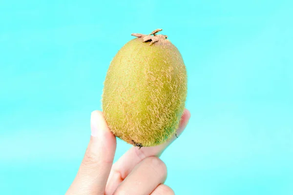 Hand Holding Kiwi Blauwe Achtergrond Met Kopie Ruimte Gezonde Concept — Stockfoto