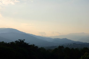 Arkaplanda gökyüzü olan dağların üzerinden gün doğumu