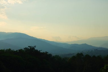 Arkaplanda gökyüzü olan dağların üzerinden gün doğumu