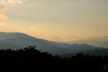 Arkaplanda gökyüzü olan dağların üzerinden gün doğumu