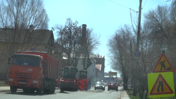 ロシア、サマラ4月20、2019:マキシムゴーリキー通り、トラックは舗装のために車にアスファルトを注ぎます。労働者は道路にアスファルトを塗った。アイスリンクスムージングホットアスファルト. — ストック動画