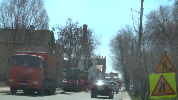 Rusko, Samara 20. dubna 2019: Maxim Gorky Street, nákladní automobil nalévá asfalt do vozu pro dlažby. Na silnici se na silnicích apliki asfalt. Žhavý asfalt s ledem. — Stock video