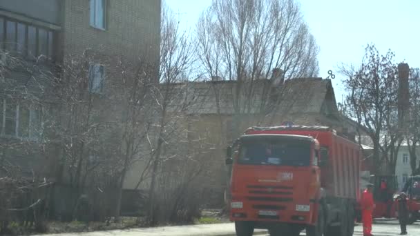 Ryssland, Samara april 20, 2019: Maxim Gorky Street, en lastbil häller asfalt i bilen för beläggning. Arbetarna tillämpade asfalt på vägen. Ishall utjämning varm asfalt. — Stockvideo